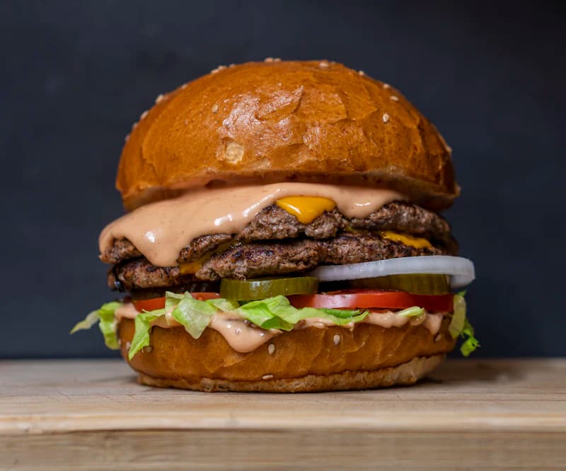 House burger with fries on a wooden table